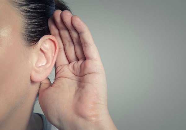woman with hand on ear