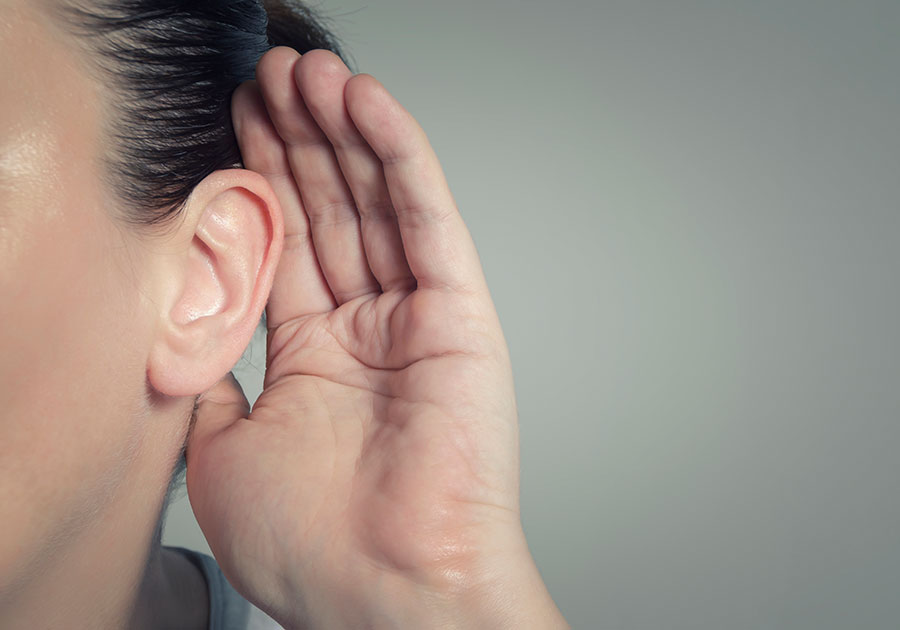 woman with hand on ear