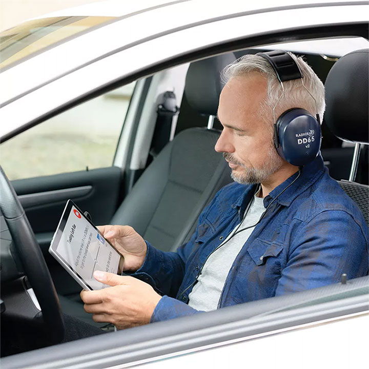 man taking hearing test in car