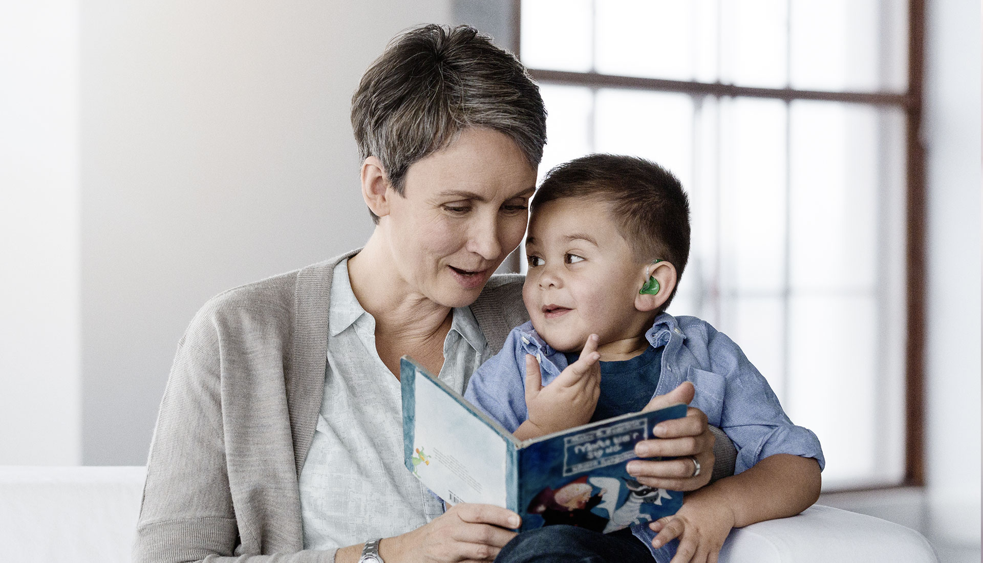 woman reading a book to a young boy
